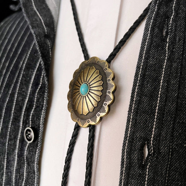 Front view of polished metal checkered vintage silver feather pendant western bolo tie showing adjustable cord and clasp details